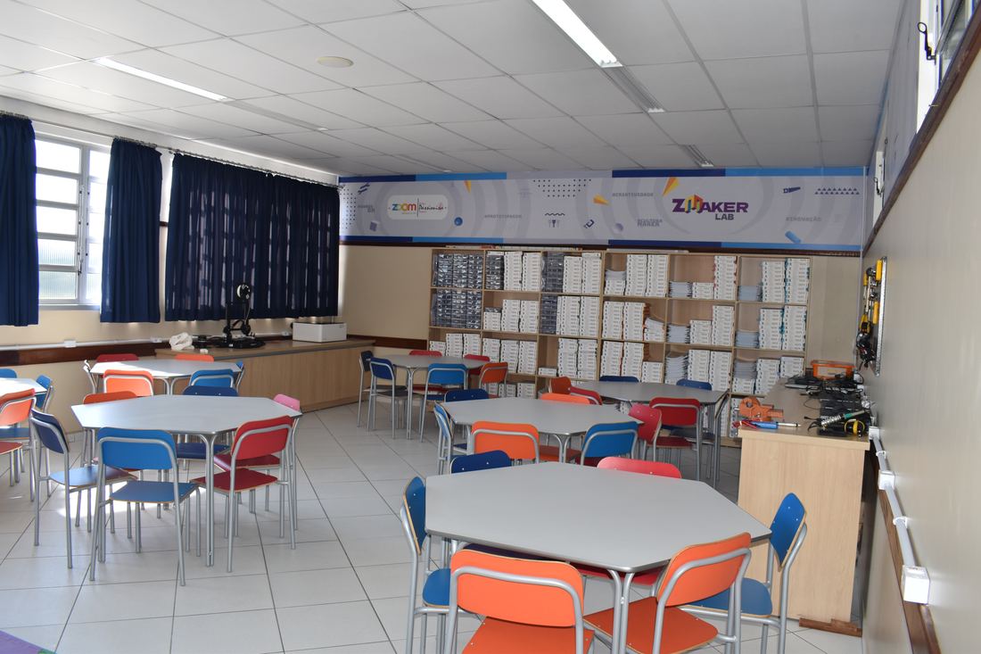 Sala de Educação Tecnológica com mesas coloridas e kits