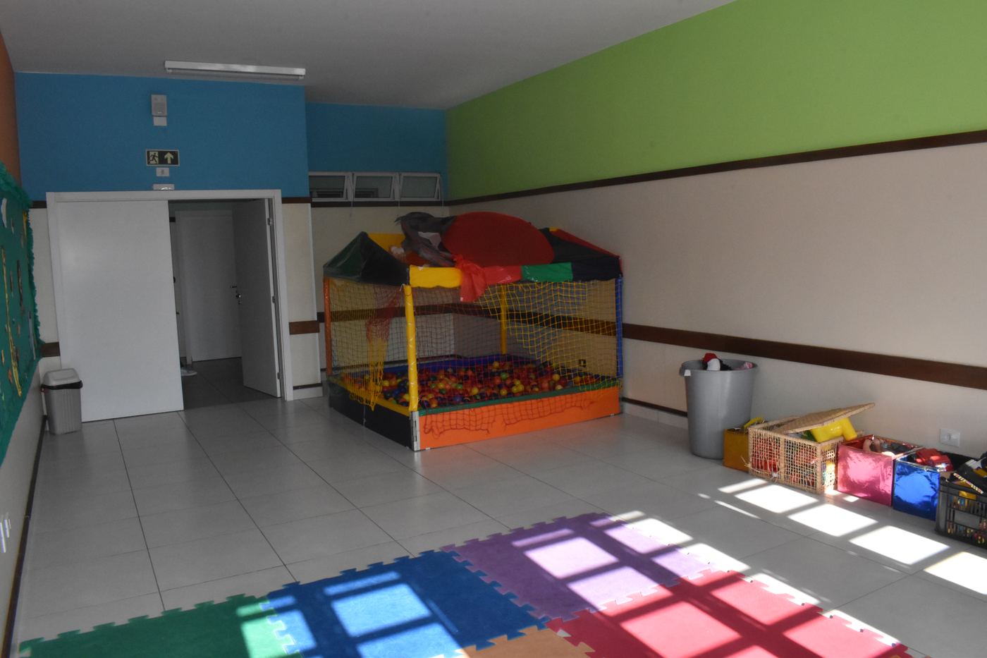Brinquedoteca colorida com tatames e piscina de bolinhas